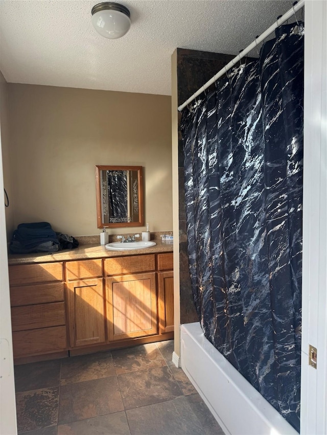 bathroom with a textured ceiling, vanity, and shower / bath combination with curtain