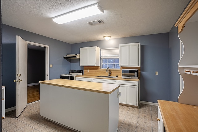 kitchen featuring electric range, sink, white cabinets, and wood counters