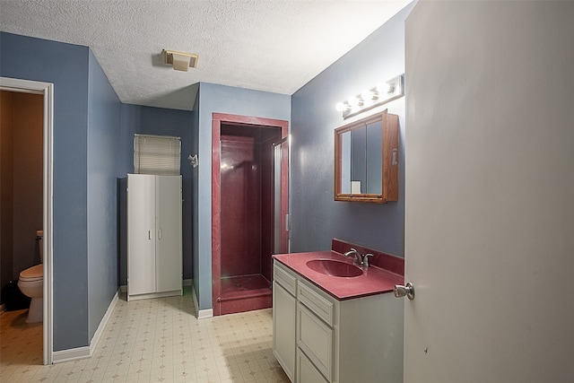 bathroom with a textured ceiling, vanity, and toilet