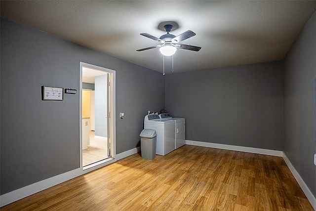 laundry area with washer and dryer, ceiling fan, and light hardwood / wood-style flooring