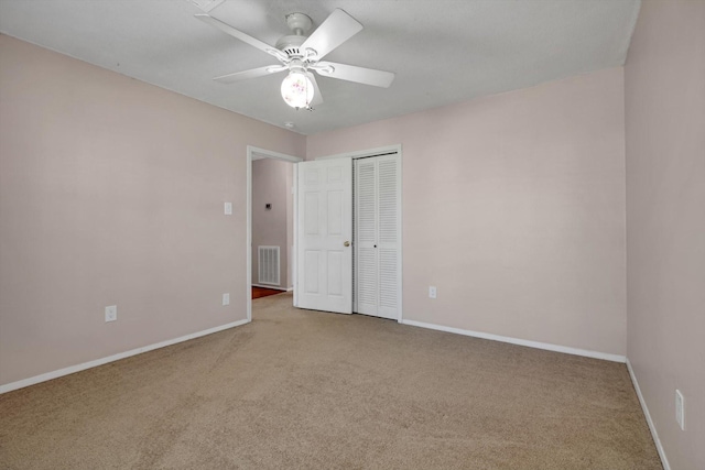 unfurnished bedroom with ceiling fan, a closet, and carpet