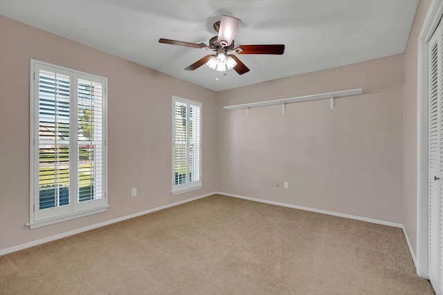 spare room featuring light colored carpet and ceiling fan