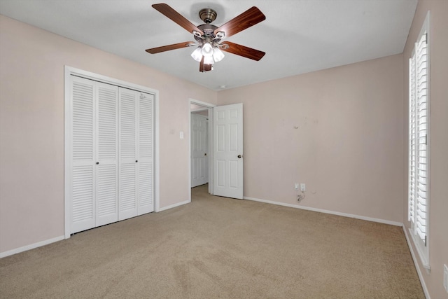 unfurnished bedroom with ceiling fan, a closet, and light carpet