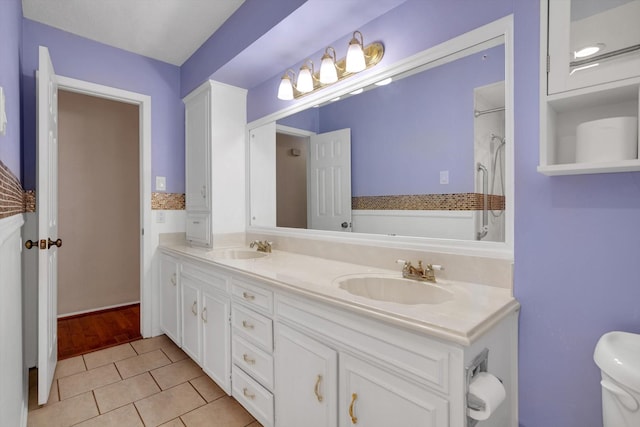 bathroom with tile patterned flooring, vanity, and toilet