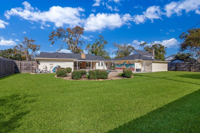 back of property featuring a fenced in pool, a yard, and a patio