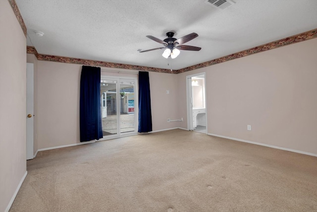 empty room featuring a textured ceiling, ceiling fan, and light carpet