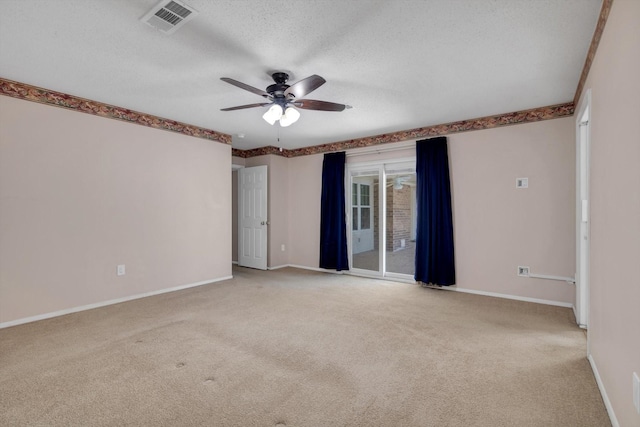 carpeted spare room featuring ceiling fan and a textured ceiling