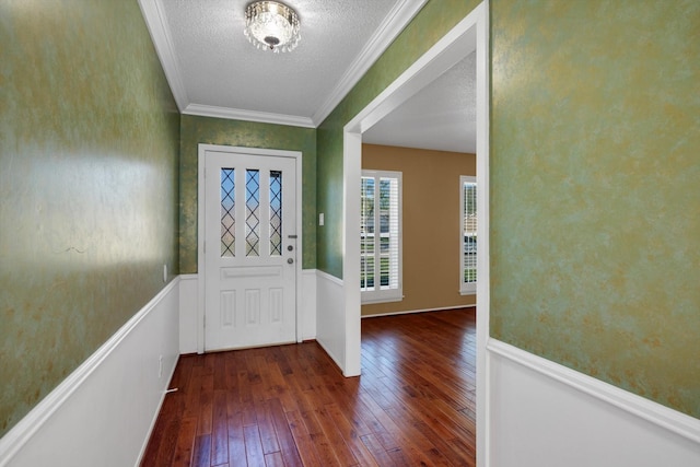 foyer entrance featuring a textured ceiling, crown molding, and dark wood-type flooring