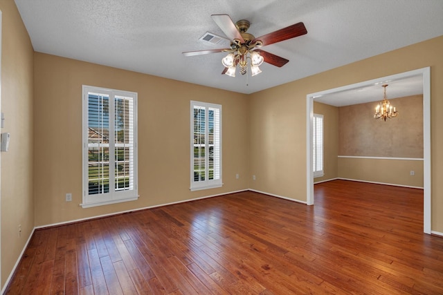 spare room with hardwood / wood-style floors, ceiling fan with notable chandelier, and a textured ceiling