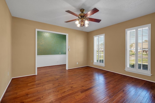 unfurnished room with a textured ceiling, dark hardwood / wood-style floors, and ceiling fan