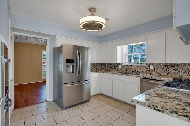 kitchen featuring backsplash, white cabinetry, and appliances with stainless steel finishes