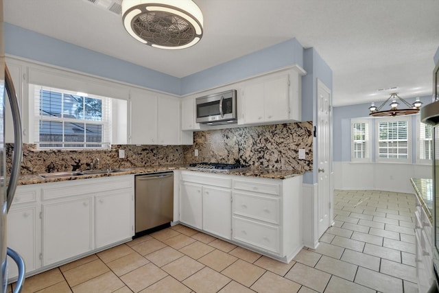 kitchen with white cabinets, backsplash, stainless steel appliances, and sink