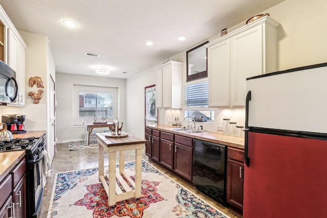 kitchen featuring decorative backsplash, sink, and black appliances