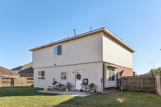 rear view of property with a yard and a patio area