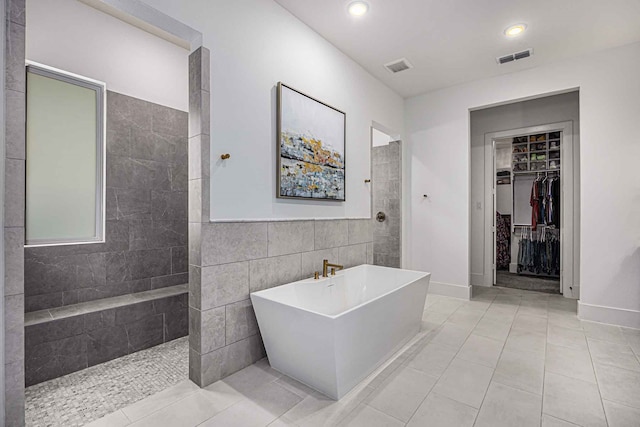 bathroom featuring tile walls, tile patterned floors, and shower with separate bathtub