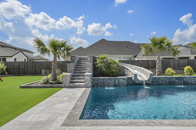 view of swimming pool featuring pool water feature, a yard, and a water slide