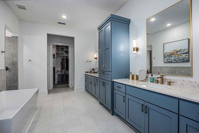 bathroom with a bathtub, vanity, and tile patterned flooring