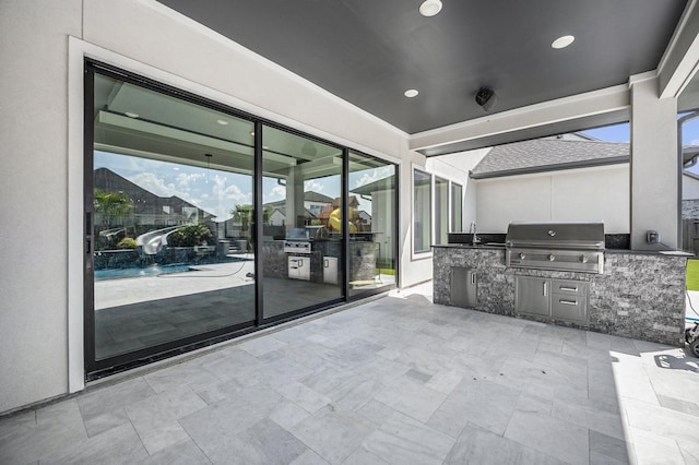 view of patio featuring sink, a grill, and an outdoor kitchen