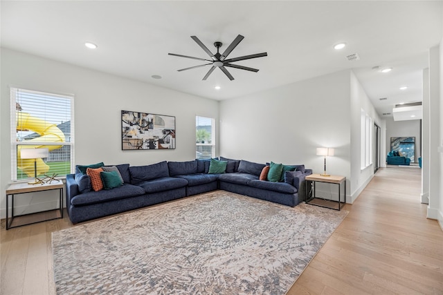 living room featuring light hardwood / wood-style floors and ceiling fan