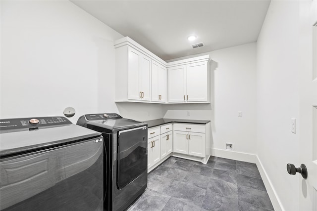 laundry room featuring washing machine and dryer and cabinets