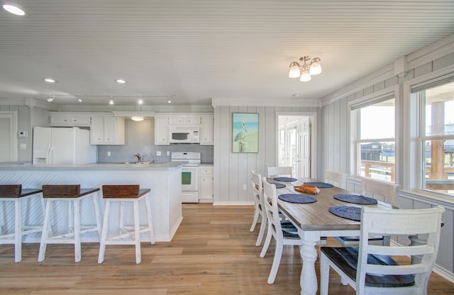 kitchen with light hardwood / wood-style flooring, white cabinets, white appliances, and sink