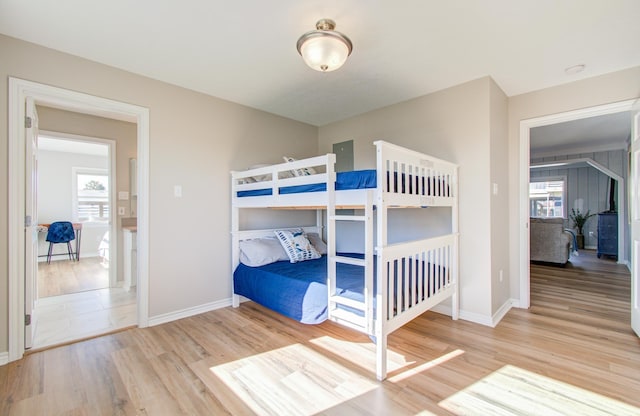 unfurnished bedroom featuring multiple windows, wood finished floors, and baseboards