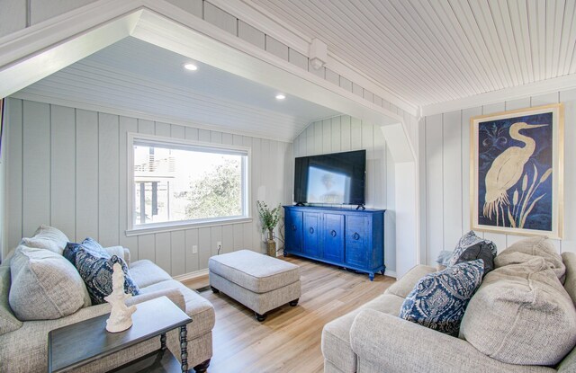 living room featuring light hardwood / wood-style floors and vaulted ceiling