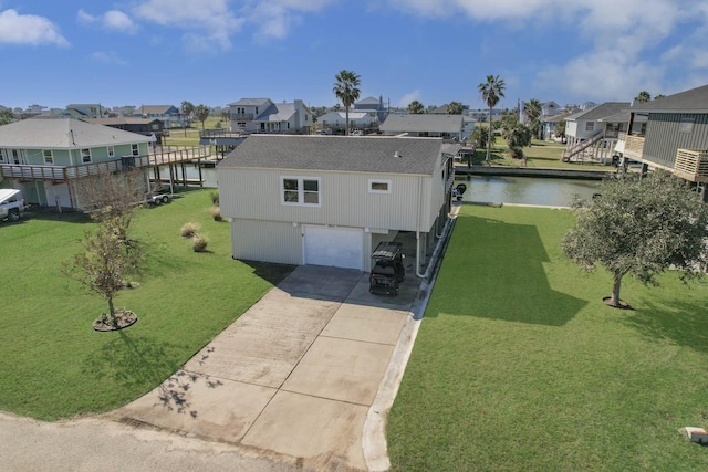 exterior space featuring a lawn, a garage, and a water view