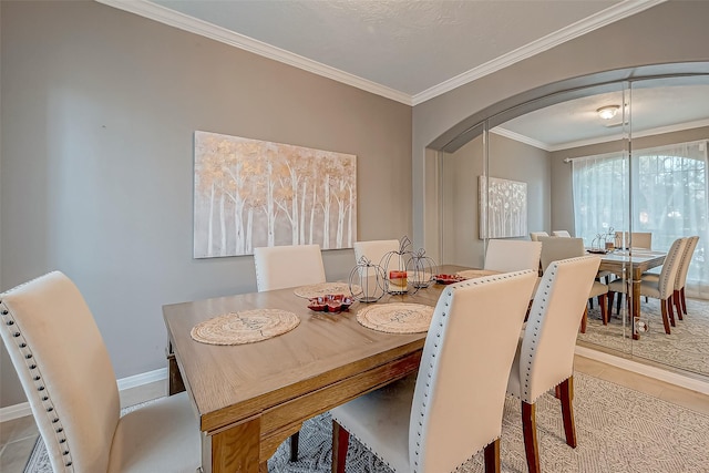 dining space with crown molding and tile patterned floors