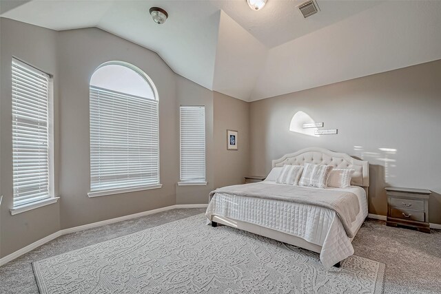 bedroom featuring lofted ceiling and light carpet