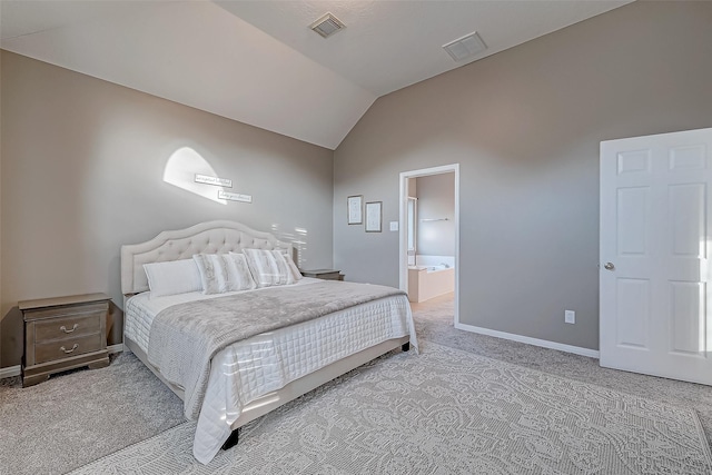 carpeted bedroom featuring ensuite bath and vaulted ceiling