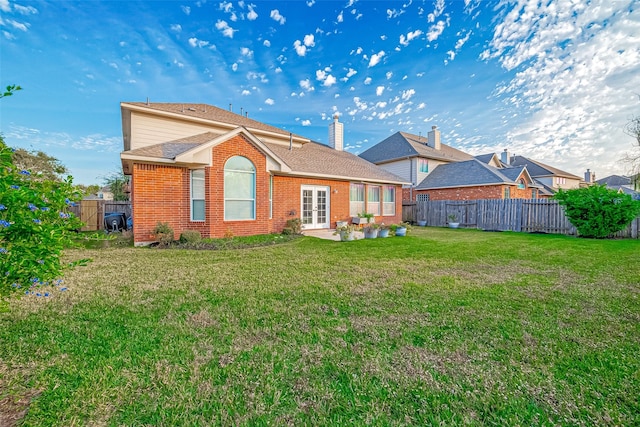 back of house featuring a patio, french doors, and a lawn