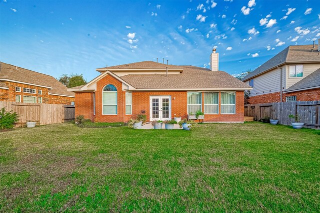 back of property featuring french doors and a lawn