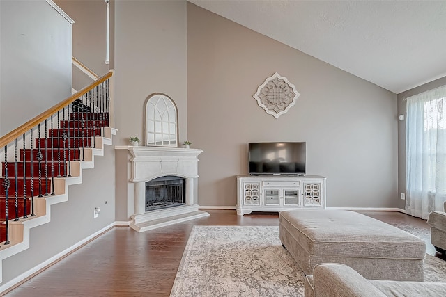 living room featuring wood-type flooring and high vaulted ceiling