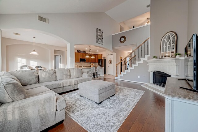 living room with high vaulted ceiling and dark hardwood / wood-style flooring