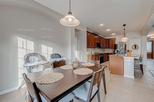 dining room featuring sink and light tile patterned floors