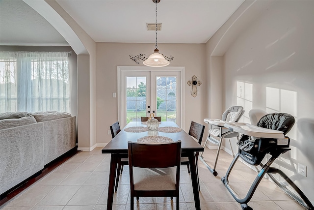 dining space with french doors and light tile patterned flooring