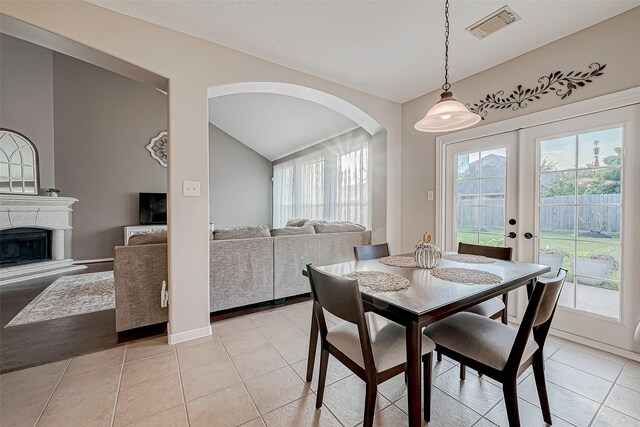 dining area with french doors, vaulted ceiling, and light tile patterned floors