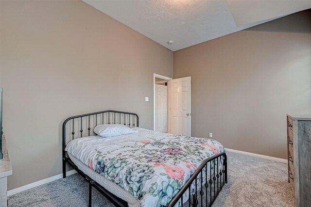 carpeted bedroom with vaulted ceiling