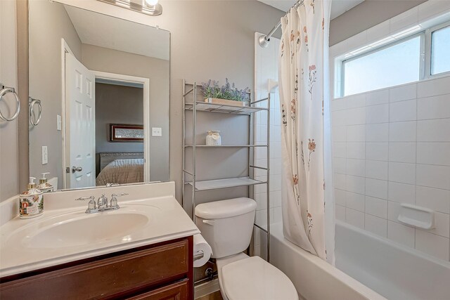 full bathroom featuring shower / bath combo, vanity, and toilet