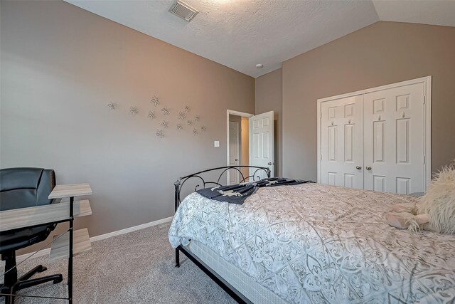 carpeted bedroom with a textured ceiling, a closet, and vaulted ceiling