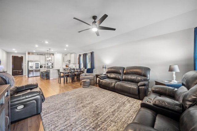 living room featuring ceiling fan and light wood-type flooring