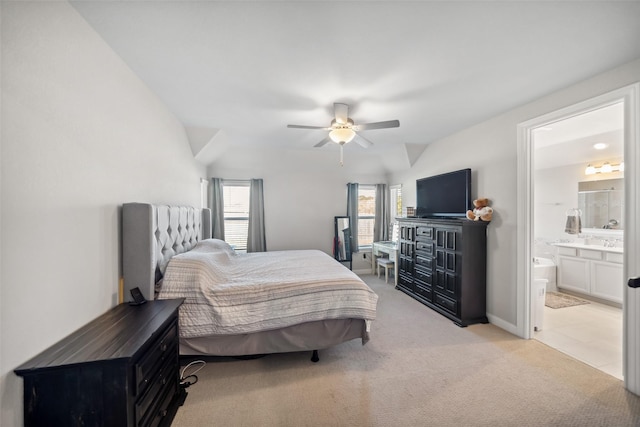 carpeted bedroom featuring connected bathroom, vaulted ceiling, and ceiling fan