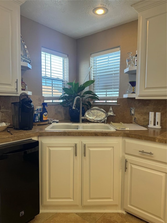 kitchen featuring sink, white cabinetry, and black dishwasher