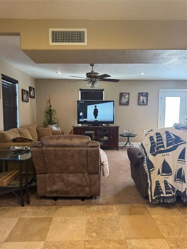 living room featuring a textured ceiling and ceiling fan