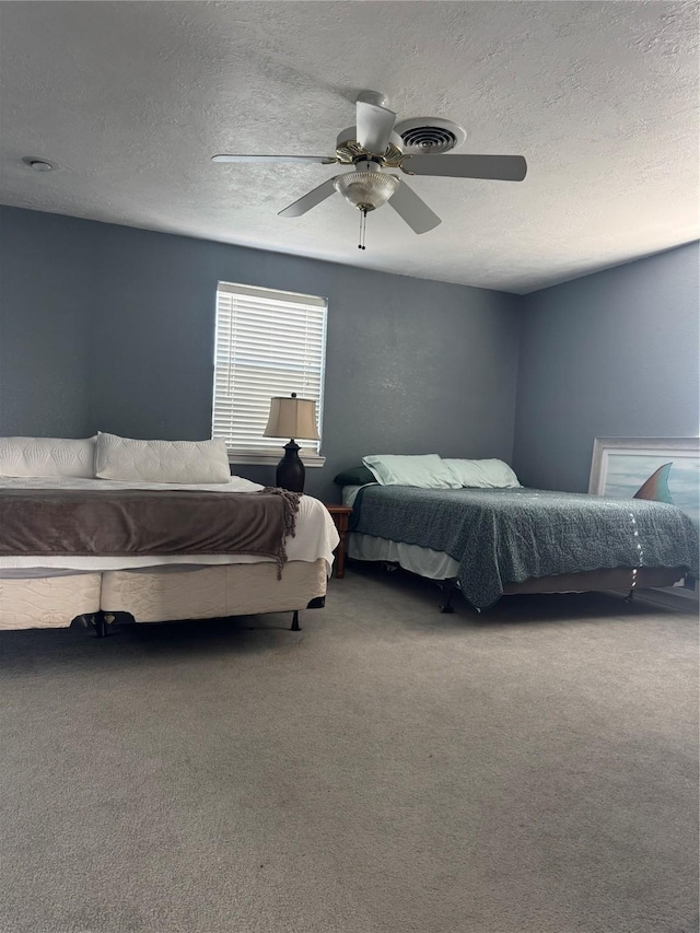 carpeted bedroom featuring a textured ceiling and ceiling fan