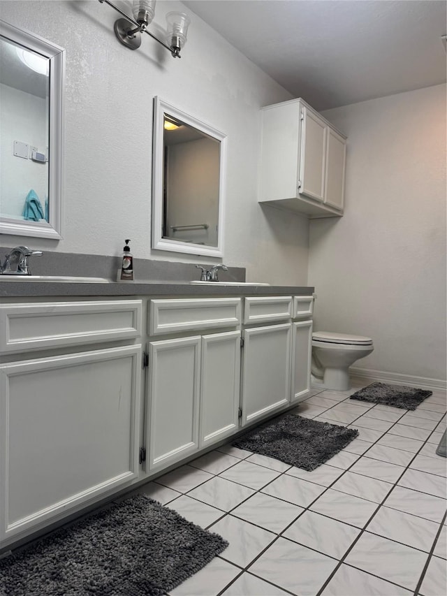 bathroom with tile patterned flooring, vanity, and toilet