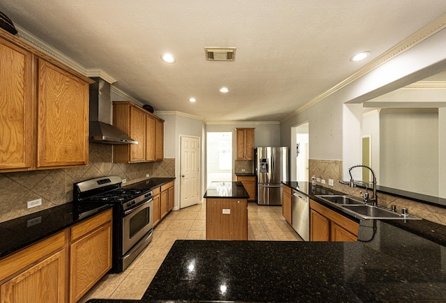 kitchen with sink, wall chimney range hood, dark stone countertops, light tile patterned floors, and appliances with stainless steel finishes