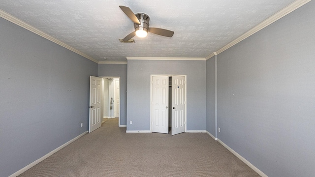 unfurnished bedroom with a textured ceiling, carpet floors, ceiling fan, and ornamental molding