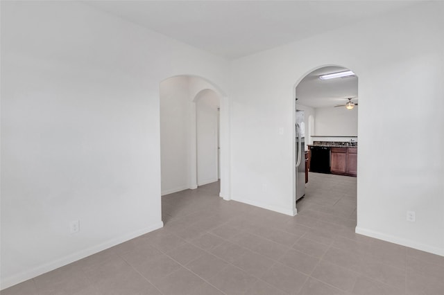 tiled empty room featuring ceiling fan